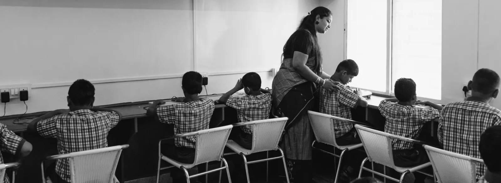 Teacher assisting visually impaired students at computers during a 3Netra outreach session in Pune, India